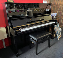 Load image into Gallery viewer, Yamaha upright piano with a bench in a room with red walls and a wooden floor.