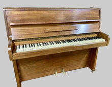 Load image into Gallery viewer, Wooden upright piano on a wooden floor with a blurred background
