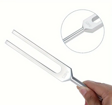 Load image into Gallery viewer, Silver tuning fork held by a hand with a close-up of the head on a white background
